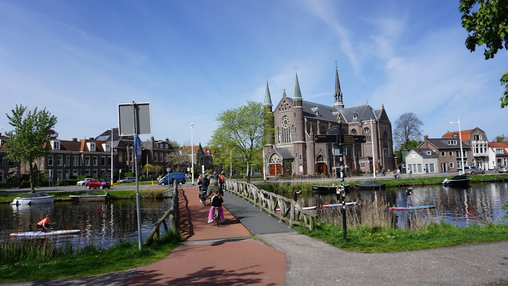 a group of people walking down a sidewalk next to a river