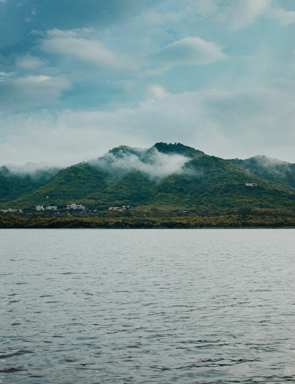 a large body of water with a mountain in the background