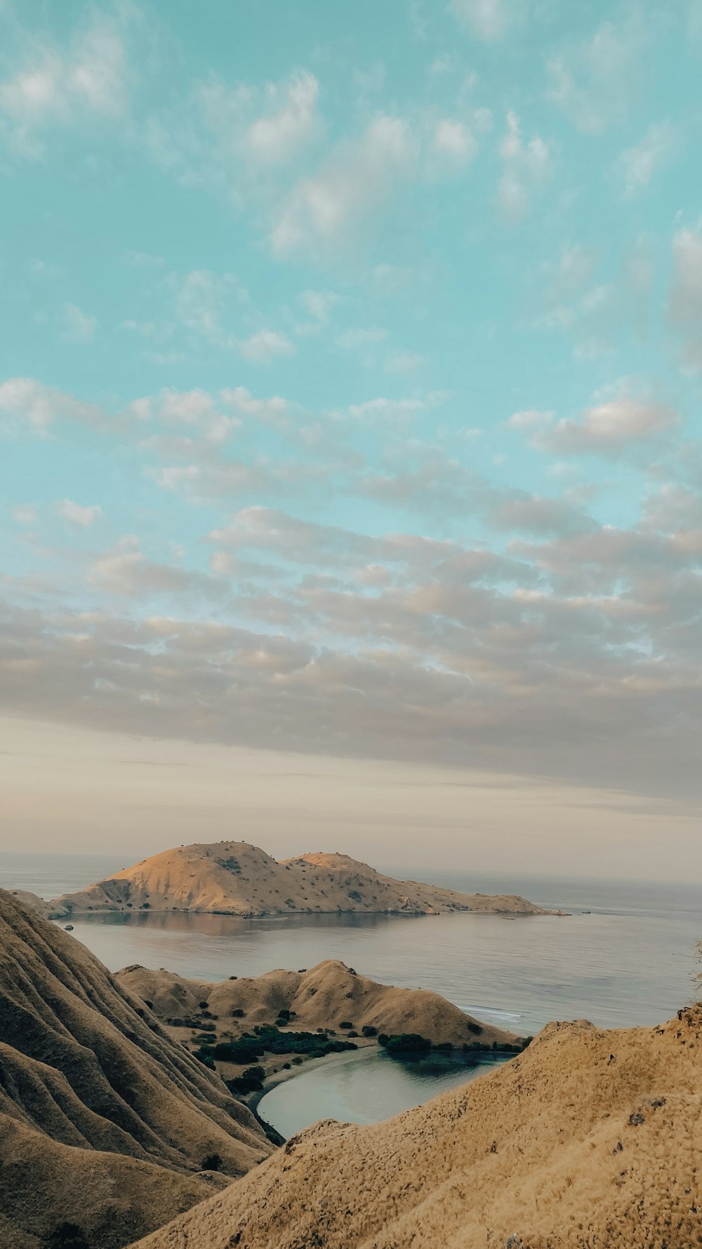 a person standing on top of a hill next to a body of water