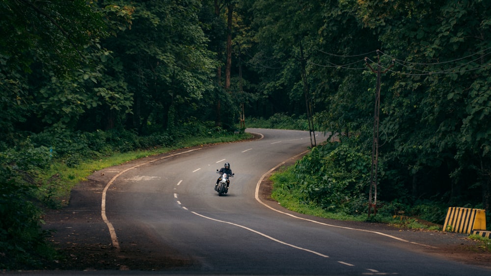 a person riding a motorcycle down a curvy road