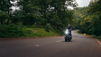 A young motorcyclist receiving guidance from an experienced mentor on a scenic northern road.