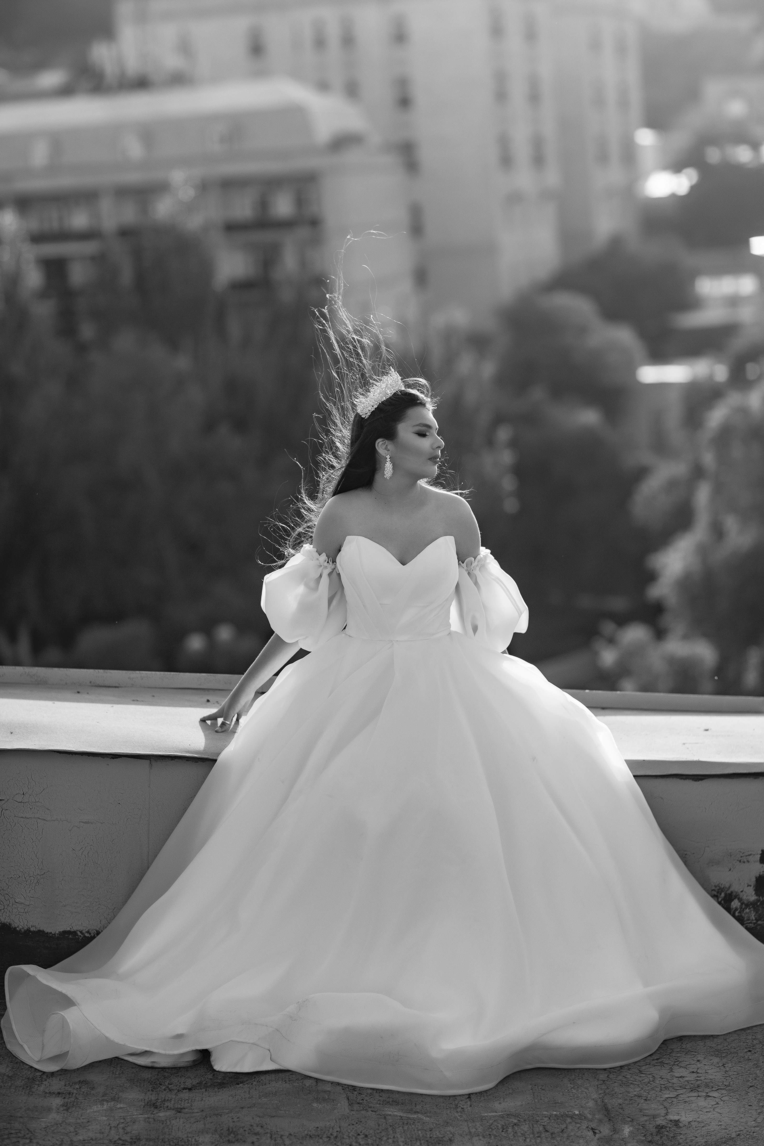a woman in a white dress standing on a ledge