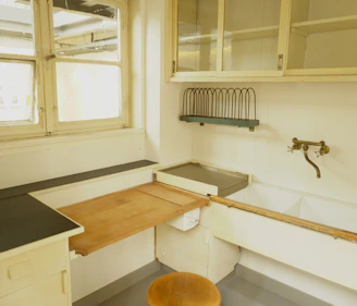 A dated kitchen corner showing tired cabinetry and outdated handles before transformation.