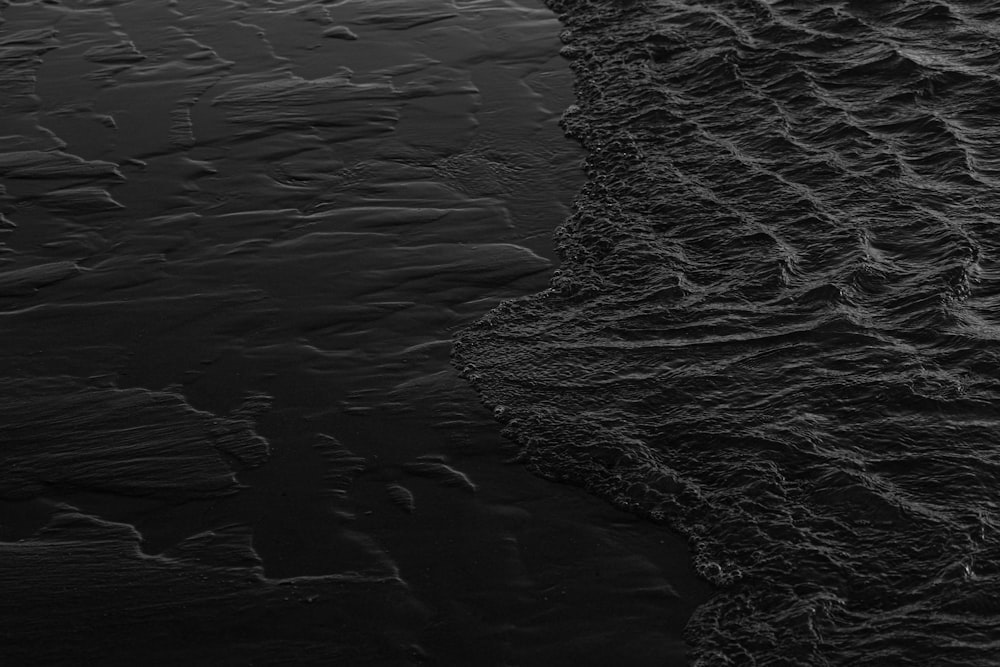 a black and white photo of water and sand
