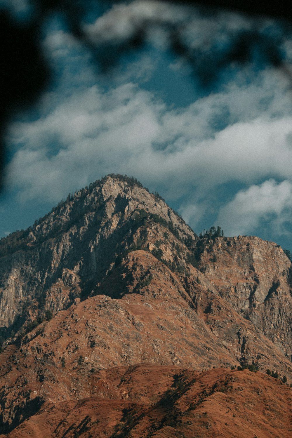 a view of a mountain with clouds in the sky