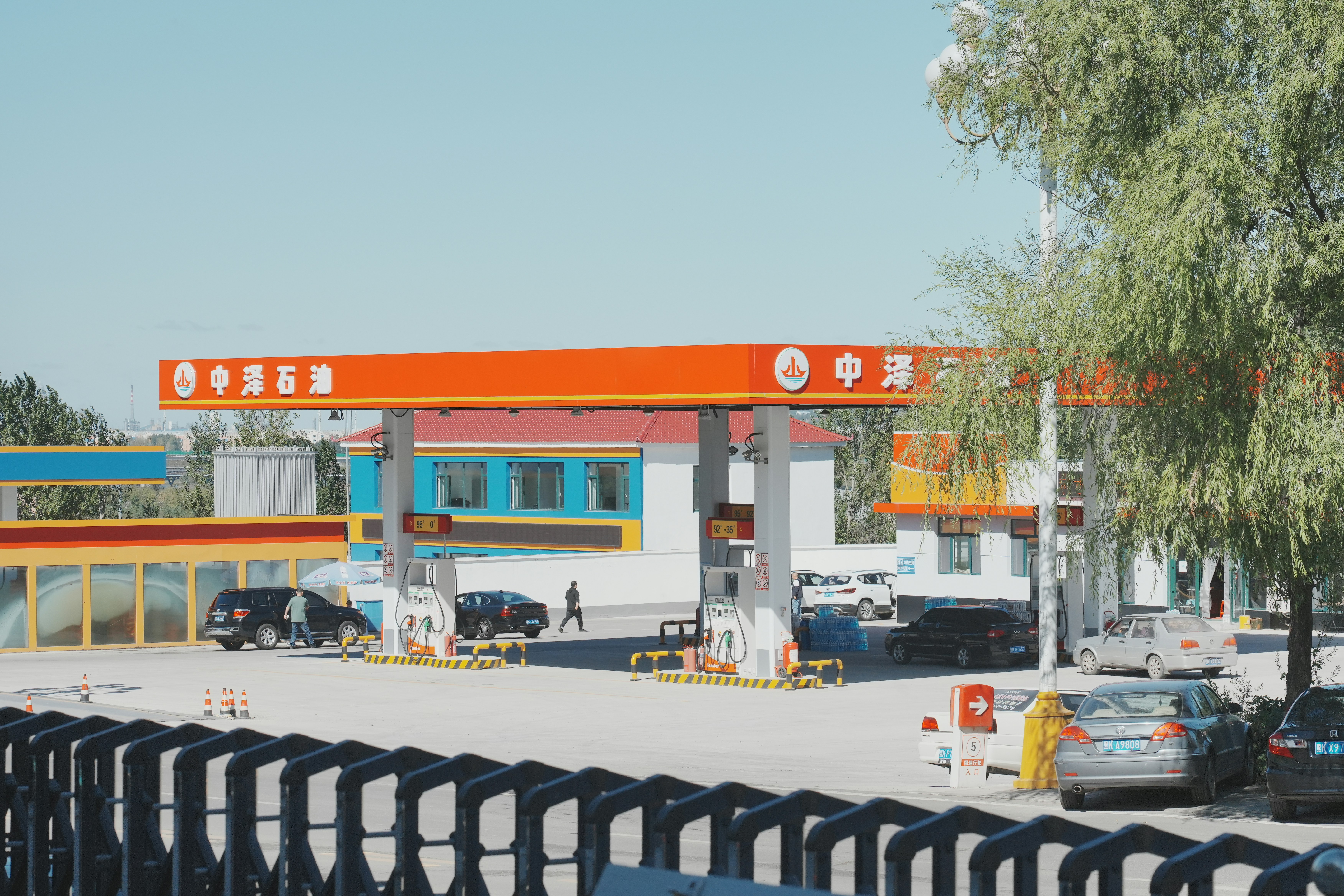 eine Tankstelle mit davor geparkten Autos