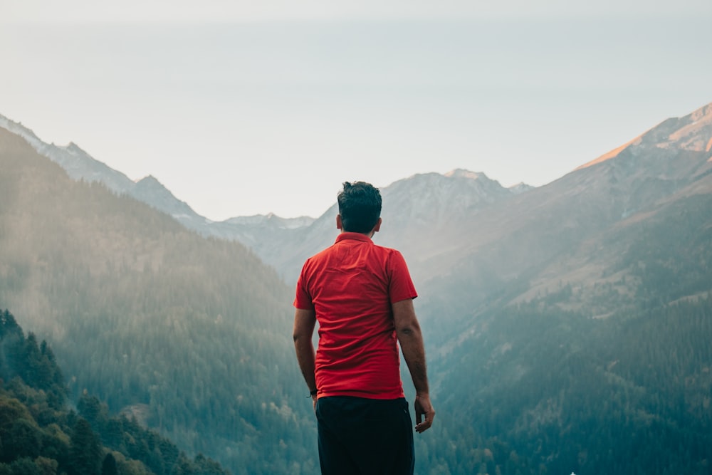 a man standing on top of a mountain overlooking a valley