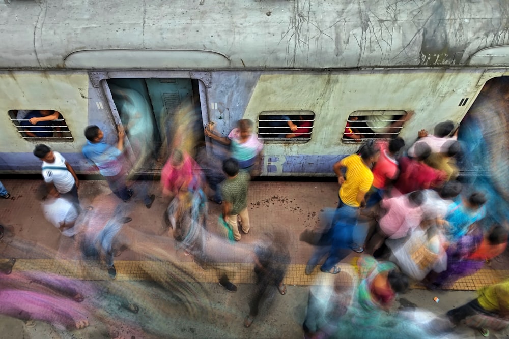 a group of people walking next to a train