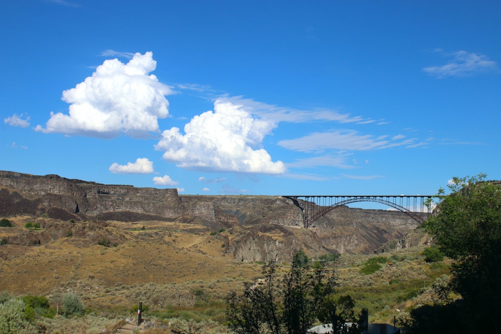 a bridge over a canyon with a sky background
