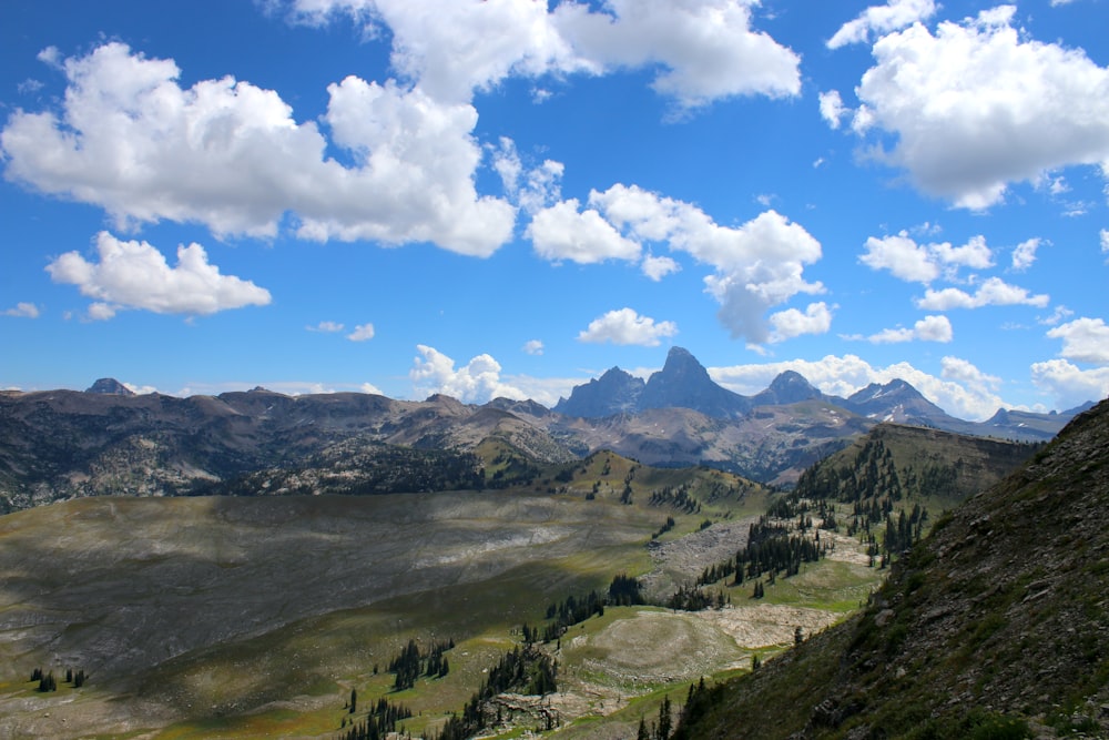 a scenic view of a mountain range with clouds in the sky