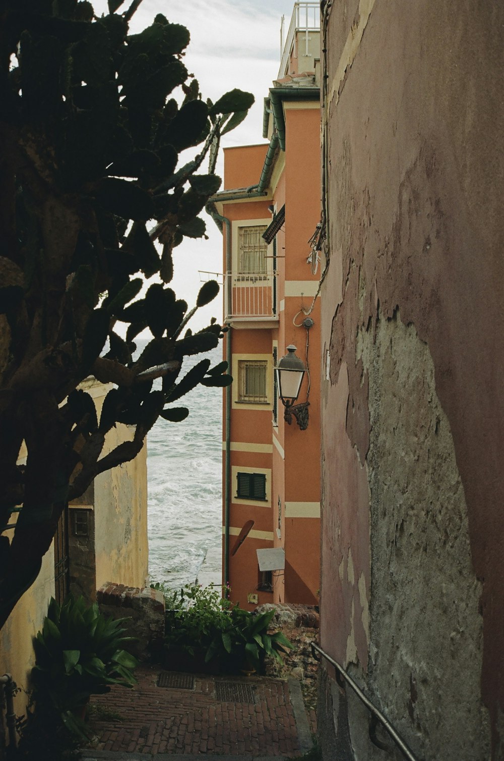 an alley way leading to a building next to a body of water