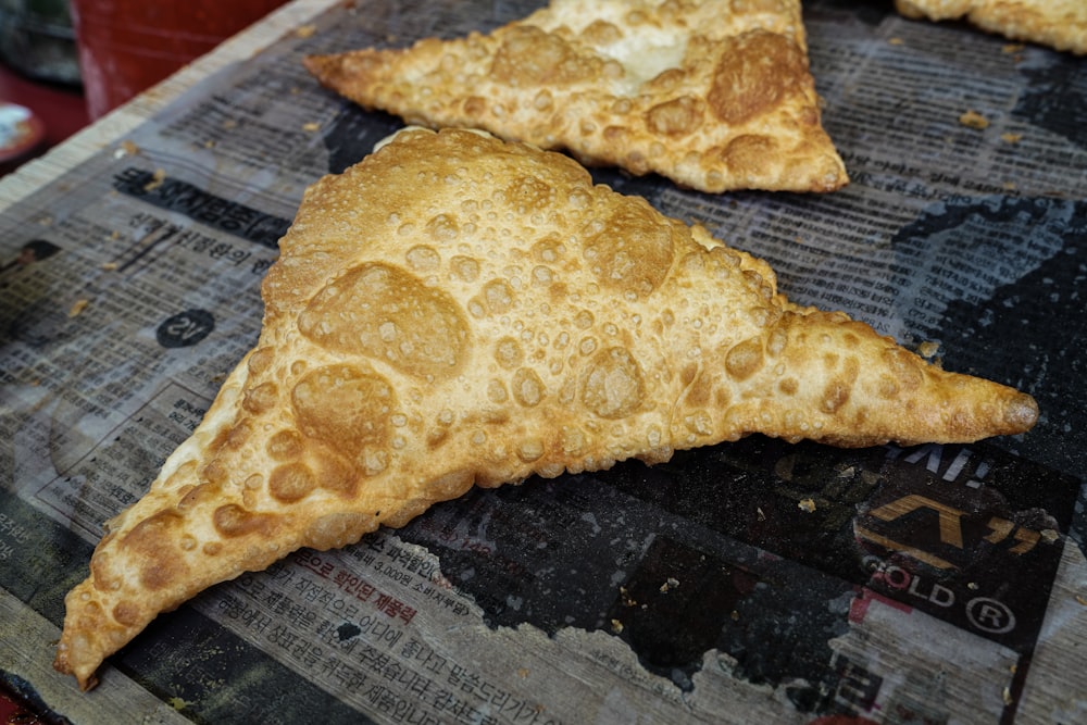 two pieces of pizza sitting on top of a cutting board