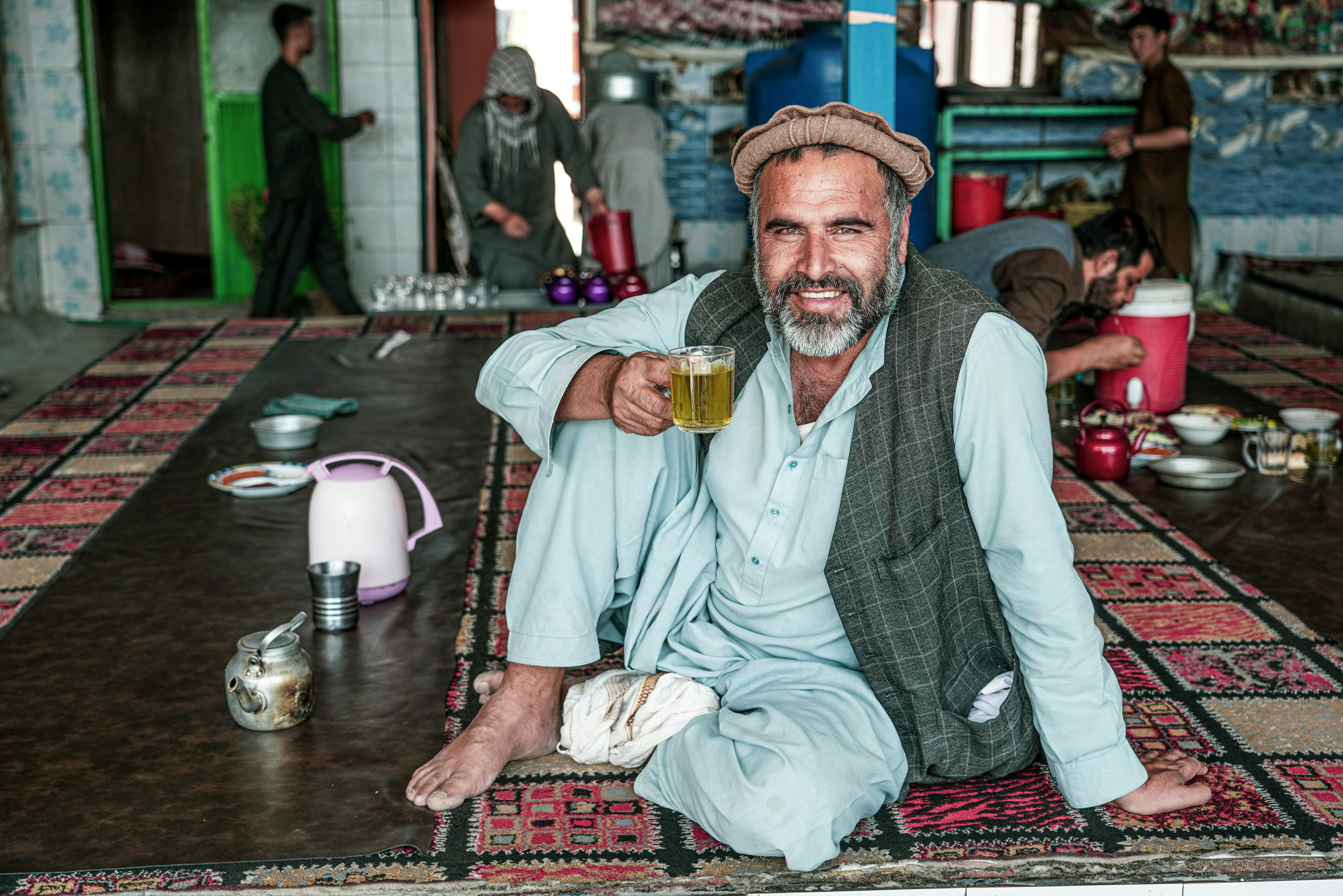Happy Afghan old man with tea