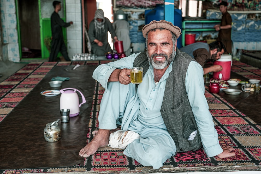 a man sitting on the floor with a glass of beer