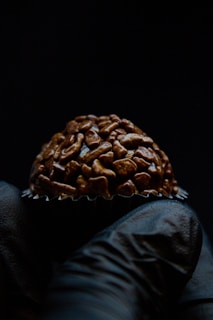 Close-up of a hand holding a beautifully decorated chocolate praline at the festival