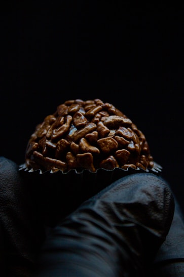 Hand holding a chocolate bonbon with a blurred background