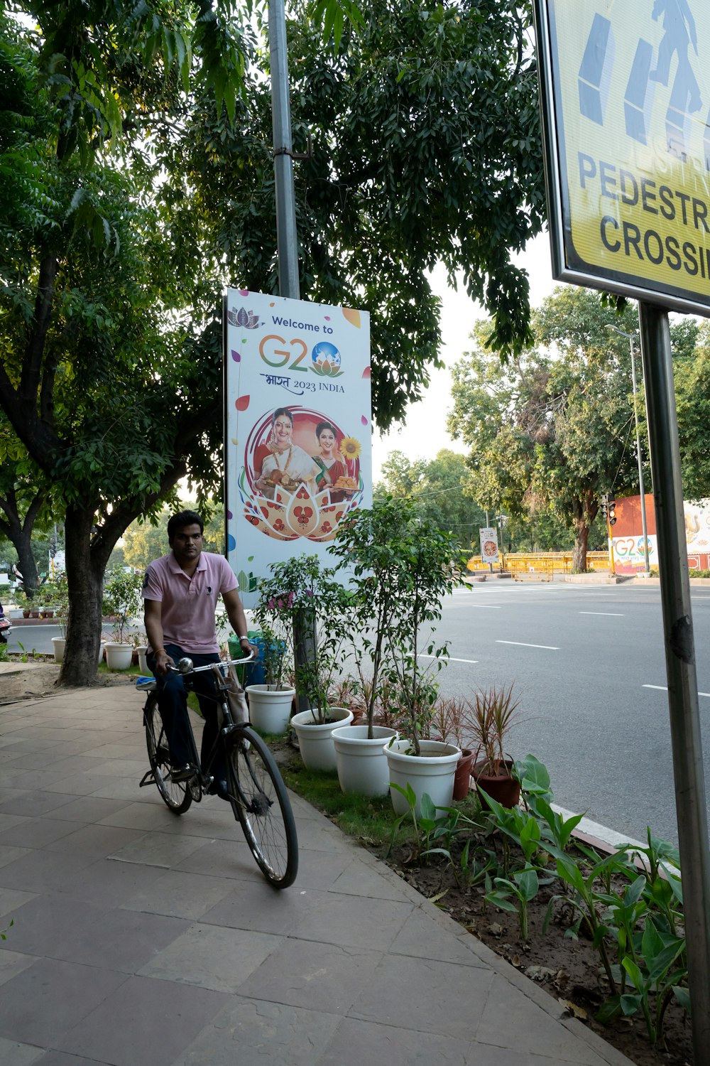 a man riding a bike down a sidewalk next to a sign