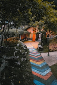 A front path embedded with colorful epoxy designs leading to a cozy home.