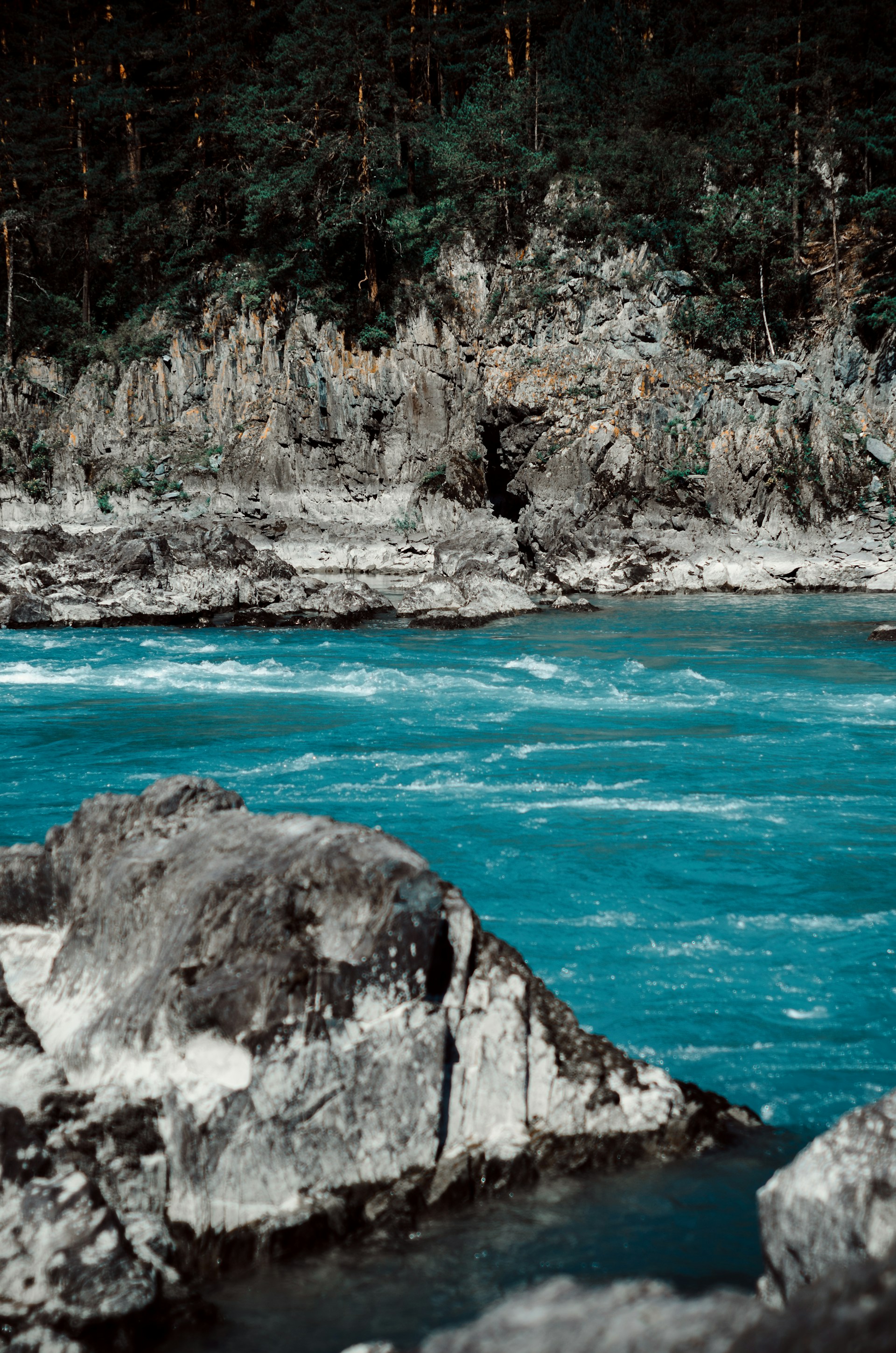 A vibrant turquoise river winding through lush green forests in the Huasteca Potosina.