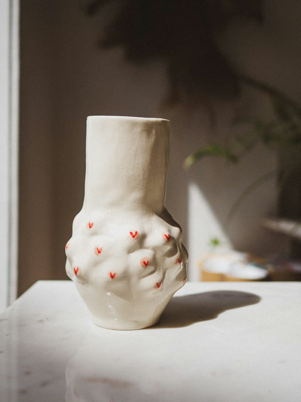 a white vase sitting on top of a table