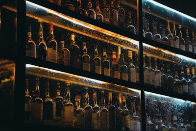 Softly lit scene showing pallets with assorted generic liqueur bottles.