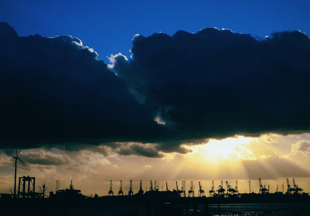 the sun is shining through the clouds over a harbor