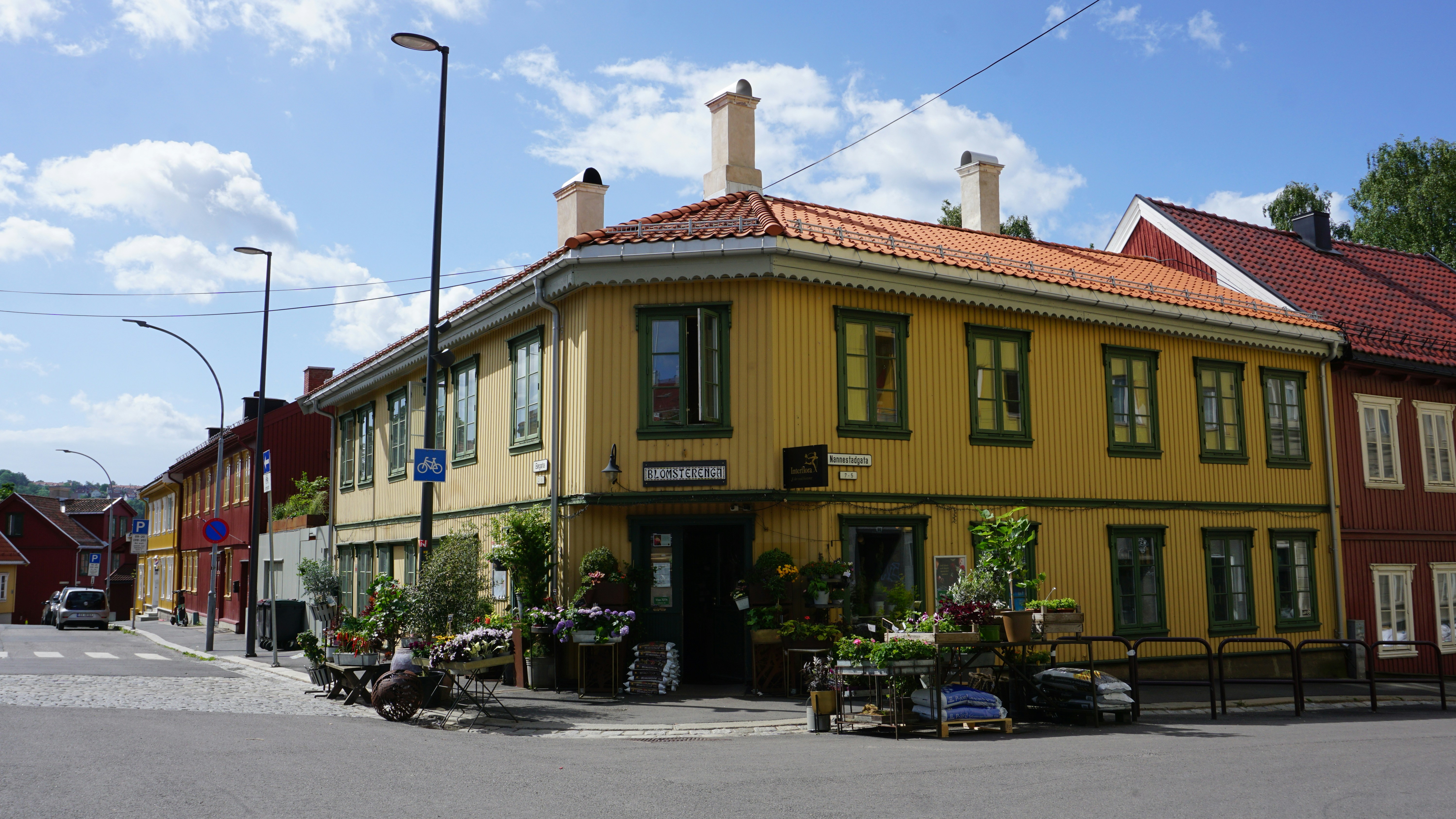 a street corner with a yellow building and a red roof