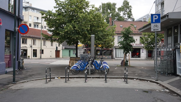 A well-organized bike parking area with various bicycles secured to racks in an urban setting.