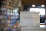 Stack of academic journals with diverse humanities topics on a wooden desk.