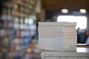 a stack of papers sitting on top of a wooden table