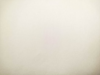 A plain, textured surface with a light beige color, suggesting a minimalistic and clean appearance.
