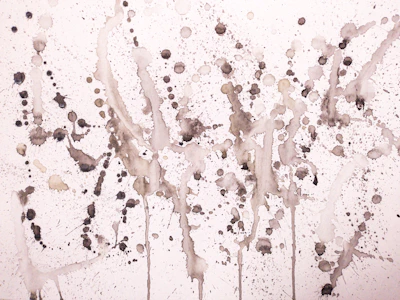 A detailed shot of spontaneous paint splatters and roller strokes in black and white.