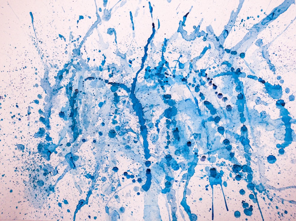 a painting of blue ink splatters on a white background