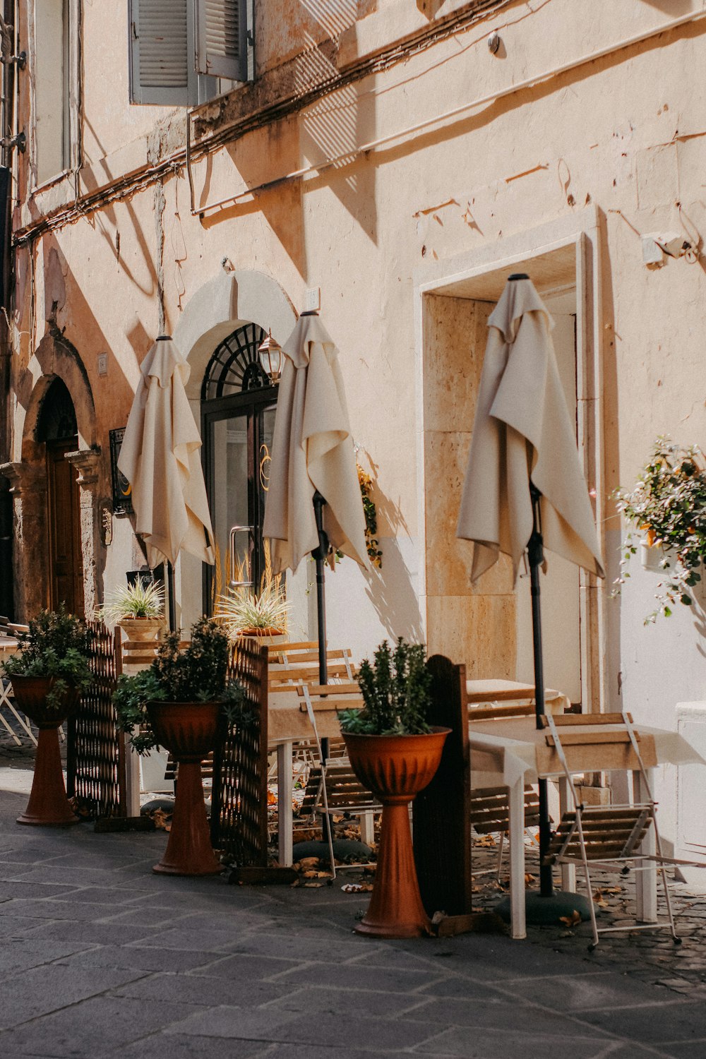 a row of tables and chairs with umbrellas over them