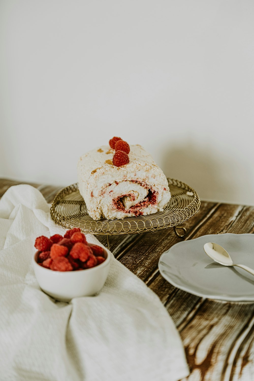 a plate of strawberries and a bowl of strawberries on a table