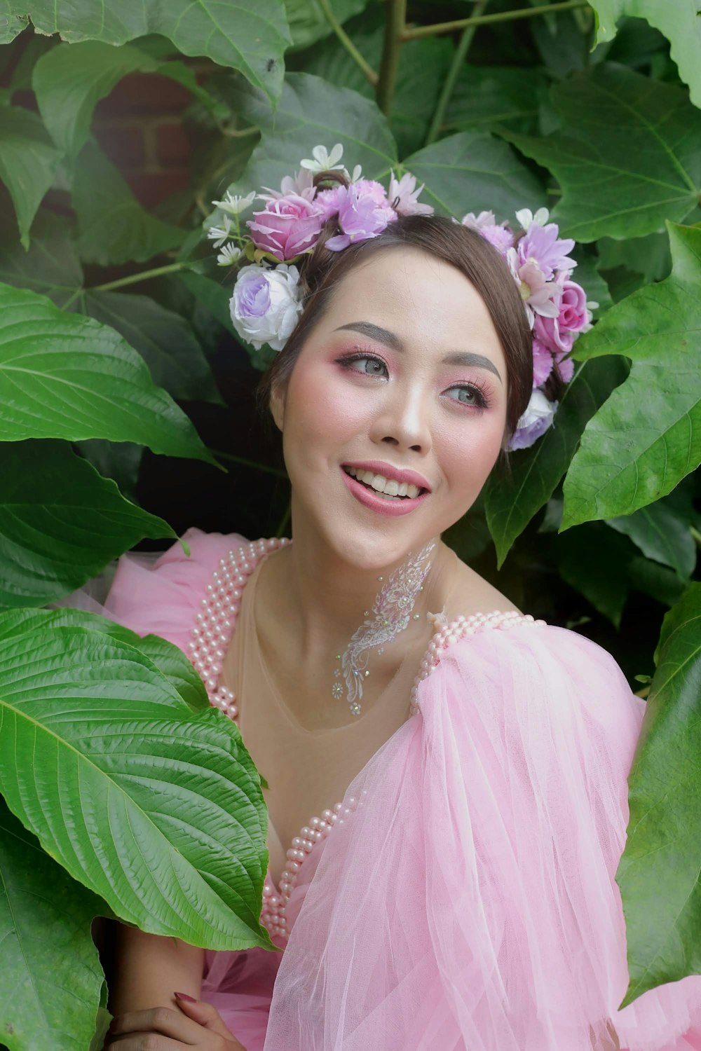 a woman wearing a pink dress and a flower in her hair