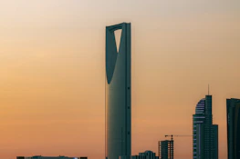 The Kingdom Centre skyscraper against a warm orange sky in Riyadh, Saudi Arabia