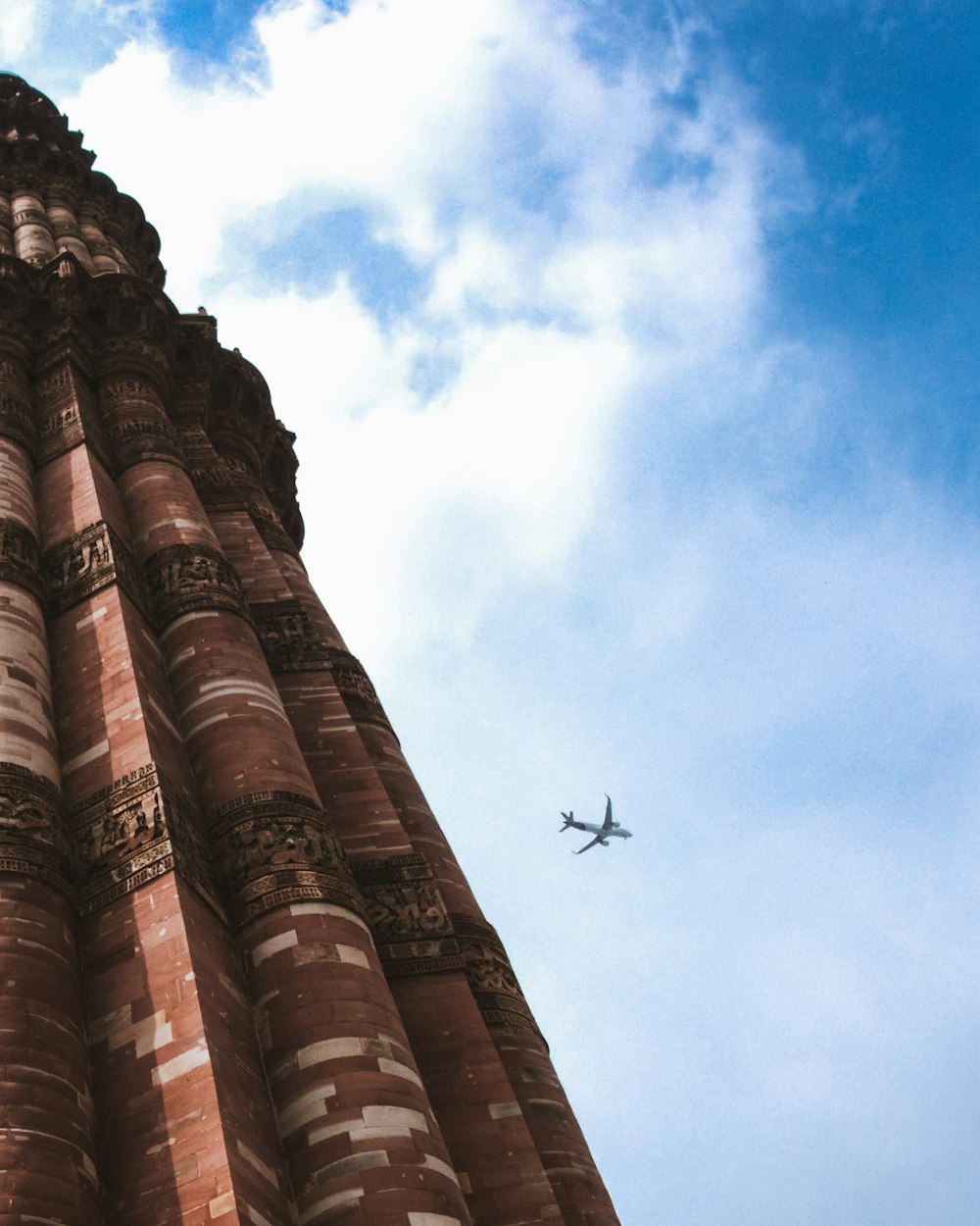 an airplane is flying over a tall tower