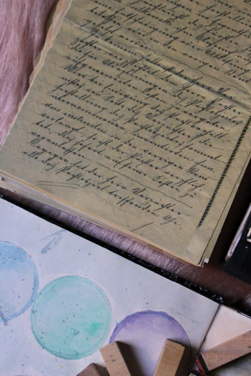 A warm, softly lit photo of an old handwritten letter resting beside a sleek tablet on a wooden table.