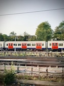 A train ambulance stationed beside railway tracks, ready for patient transport.
