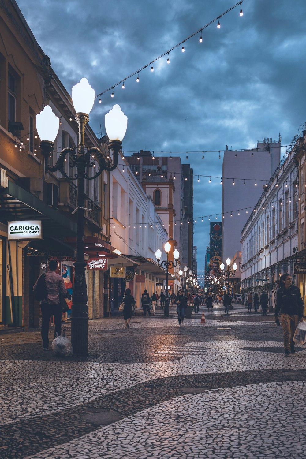 a cobblestone street with people walking on it