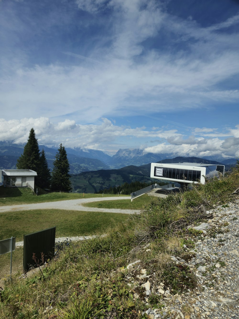 a house on a hill with mountains in the background