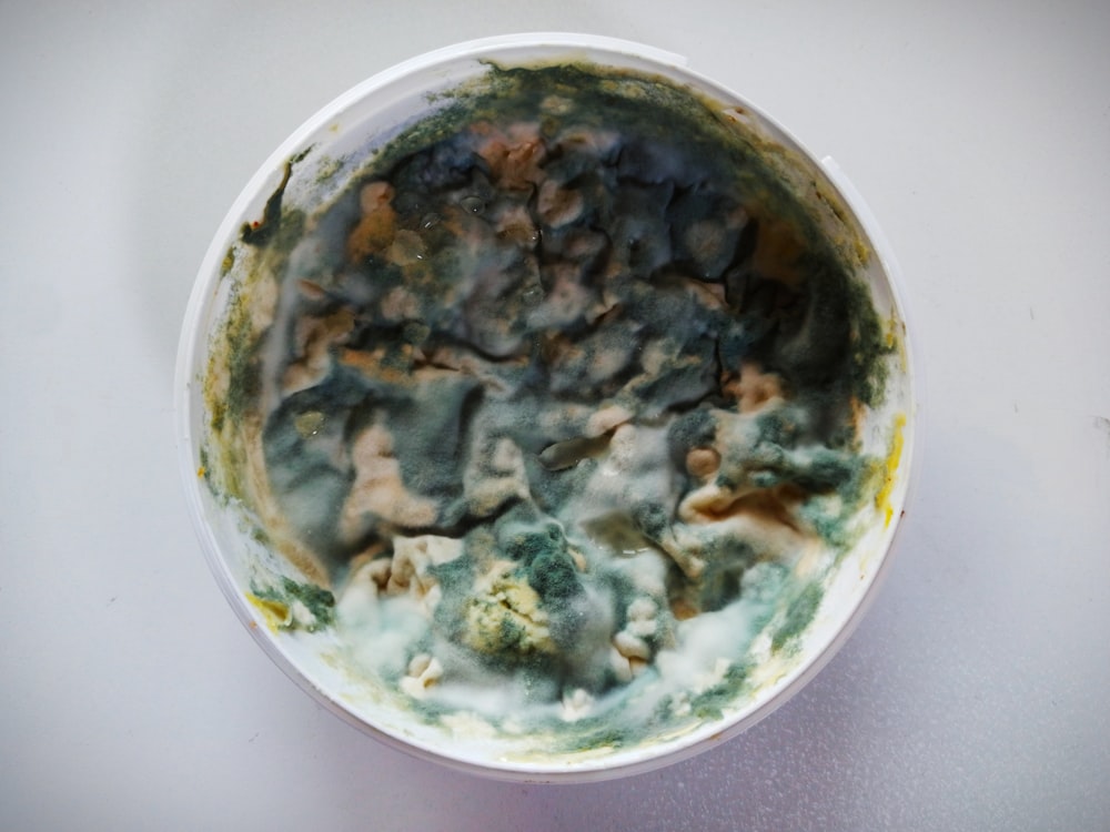 a white bowl filled with food on top of a table