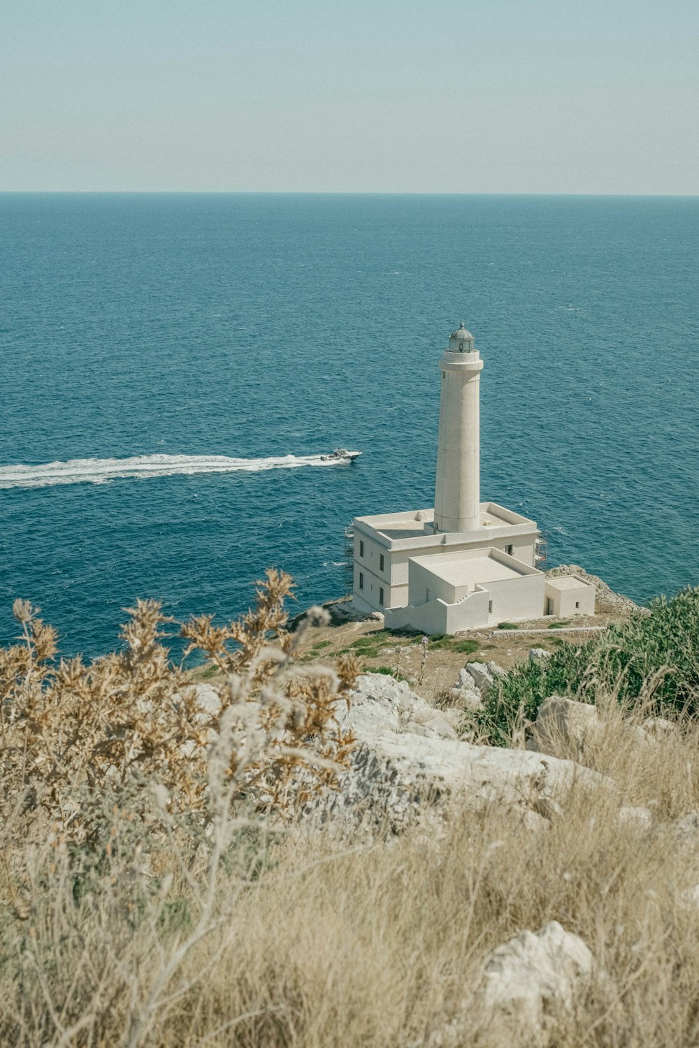 a light house sitting on top of a hill next to the ocean