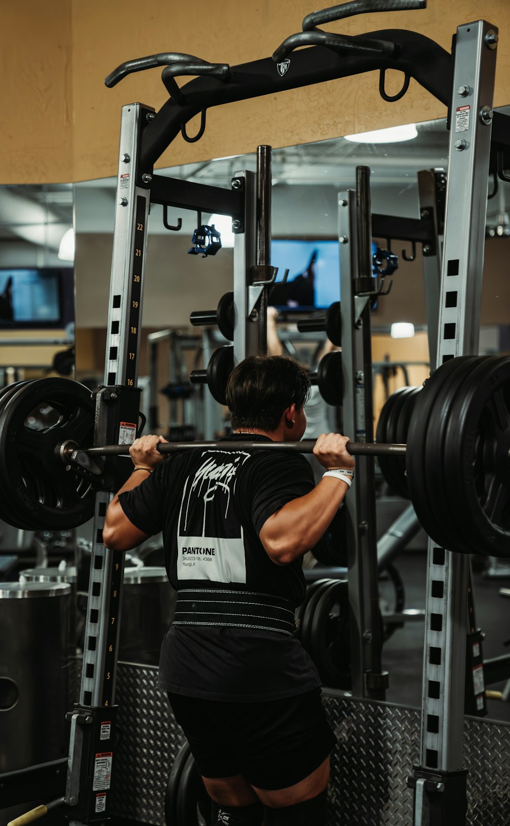 a man doing a squat with a barbell in a gym