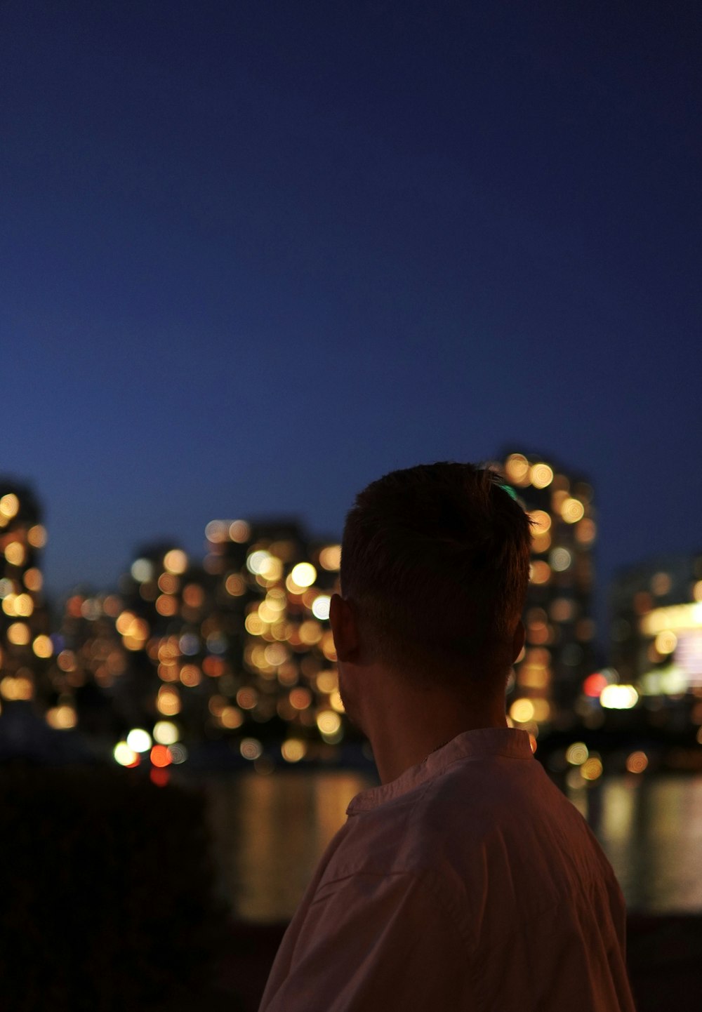 a man looking out over a city at night