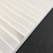 A close-up of various textured paper sheets arranged neatly on a wooden table.