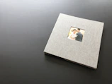 A beautifully designed printed photo album open to a page with candid wedding photos.