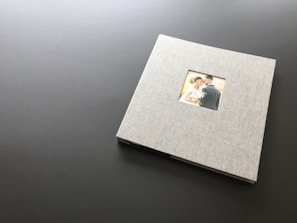A beautifully crafted wedding album open to a spread of candid and portrait photos.