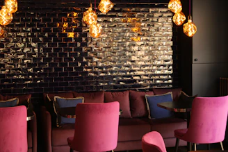 A cozy lounge area with comfortable seating and creative artwork on the walls.